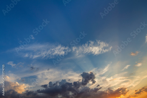 Panorama of sky at sunrise or sunset. Beautiful view of dark blue clouds lit by bright orange yellow sun on clear sky. Beauty and power of nature, meteorology and climate changing concept.