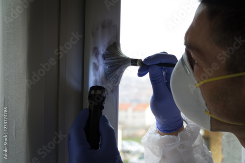 Forensic expert find fingerprints on the window. Crime scene