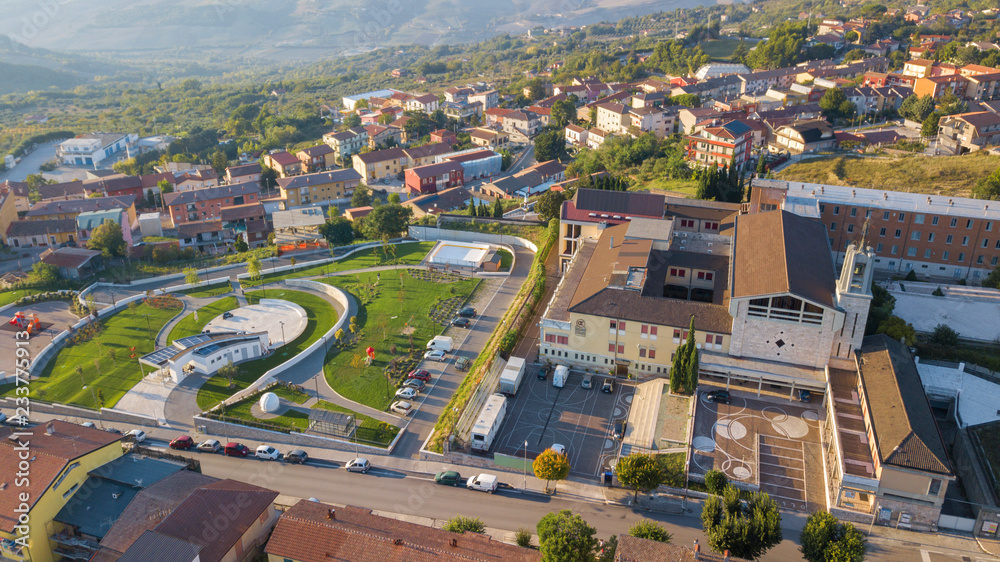 Aerial view of a convent at an Italian Catholic church. One side of the structure is a large park and a bell tower and is located in Montecalvo Irpino, Italy.