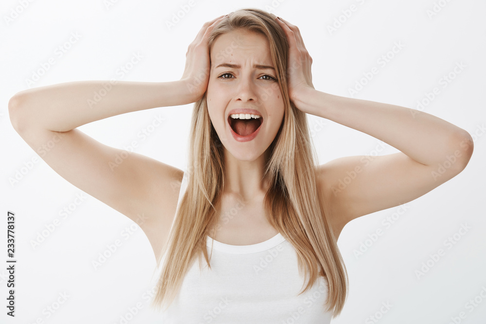 Girl panicking screaming, losing temper holding hands on head from overthinking, looking worried and depressed standing over gray background, yelling concerned and desperate Girl panicking screaming, losing temper holding hands on head from overthinking, looking worried and depressed standing over gray background, yelling concerned and desperate