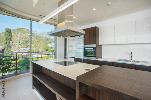 Interior of light spacious kitchen with large panoramic windows in a luxury villa