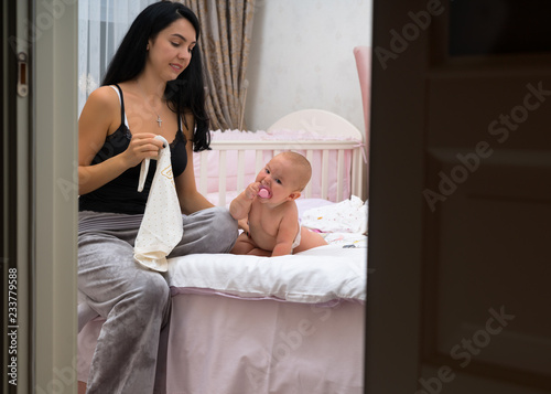 Young mother changing the nappy of her baby