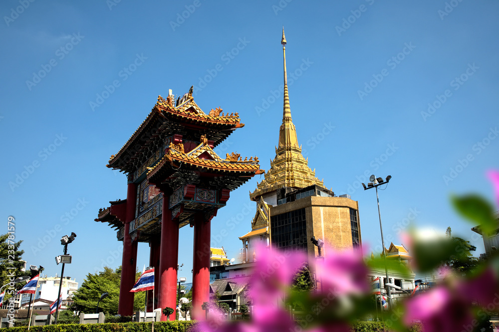 Architectural detail of Buddhist temple, Wat Traimit and Chinatown Gate over blue sky in Bangkok, Thailand Architectural detail of Buddhist temple, Wat Traimit and Chinatown Gate over blue sky in Bangkok, Thailand