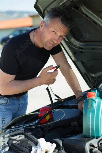 Oil change in car. Man repairing the engine in the car. Self-changing oil in own car. Man looks under the hood of his auto © Khorzhevska