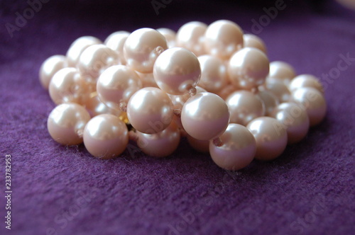 Jumbled strung pearls on purple cashmere background