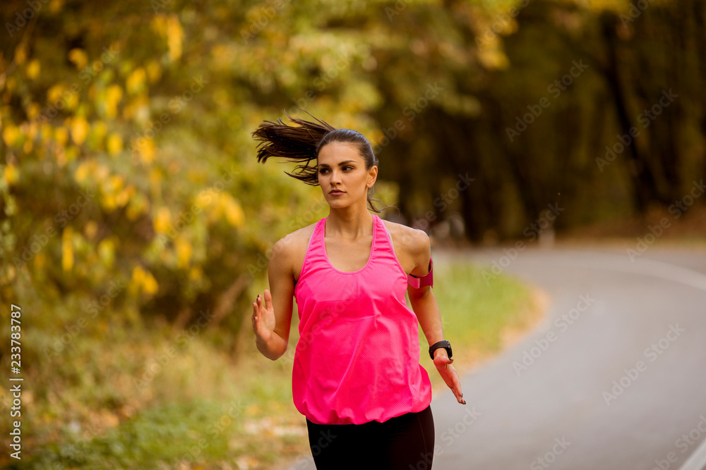 Young fitness woman running at forest trail Young fitness woman running at forest trail