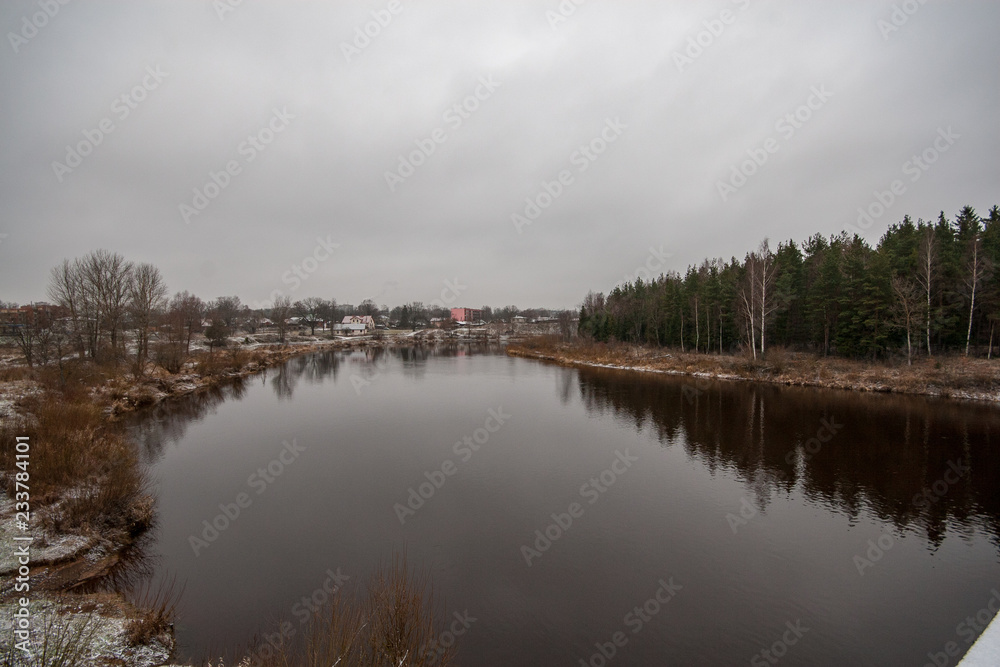 Obraz premium river of Gauja near Valmiera with sandstone cliffs and calm water in early winter