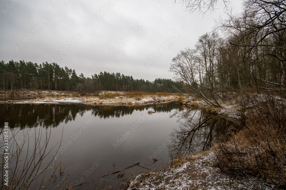 river of Gauja near Valmiera with sandstone cliffs and calm water in early winter