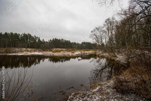 river of Gauja near Valmiera with sandstone cliffs and calm water in early winter
