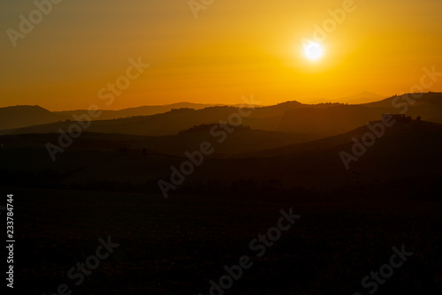 Amazing sunset in Tuscany, Italy, Europe. Beautiful landscape with sunset among the tuscan hills..