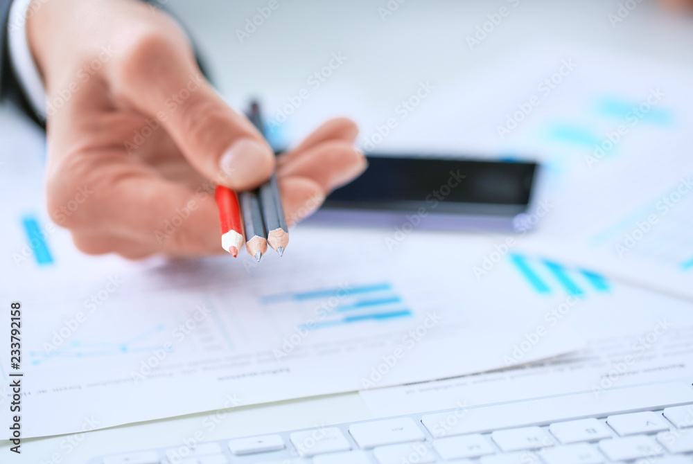 Man's hand giving color pencils that you can make notes in charts and tables. Man's hand giving color pencils that you can make notes in charts and tables.