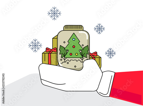 Cute decorated glass with small christmas tree and present holding by santa in the snowy day