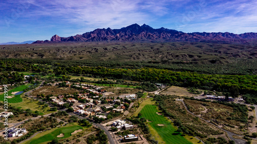 Aerial, drone view of Tubac, Arizona with blue sky, green flora including palo verde trees, purple mountains photo