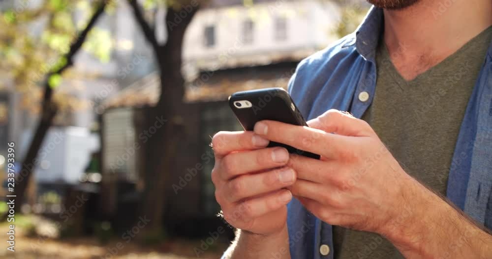 Close up view of Businessman’s Hands Typing on Mobile Phone. Handsome Man Holding Modern Device in his Hands. Looking Satisfied. Smiling Sincerly. Portrait of Handsome Man.