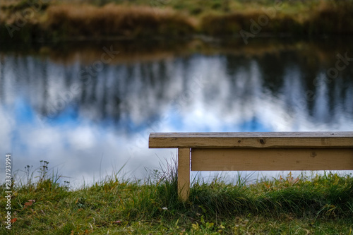 old wooden bench by the water in forest