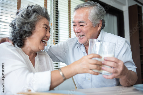 Happy Asian Senior Couple laughing and drinking milk.