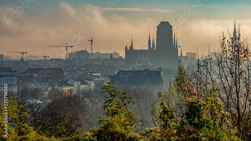 Fototapeta Naklejka Na Ścianę i Meble -  Foggy and cloudy cityscape of Gdansk with St. Mary's Basilica.