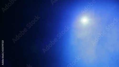 Scene illumination with a blue light beam of a spotlight in smoke from a smoke machine