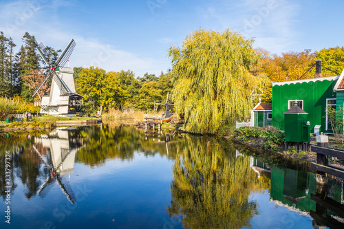 Historic Dutch scene with an old shipyard, wooden barn and water windmill in the open air museum in Arnhem in the Netherlands photo