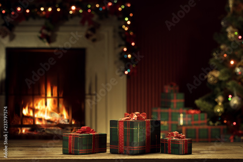 view of wrapped gifts and fireplace with christmas tree on the back