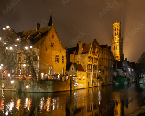 Night view of a canal in Bruges, Belgium with the belfry tower in the background