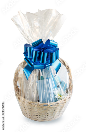 Fotografía gift basket, hamper packed in transparent paper with a big blue bow isolated on