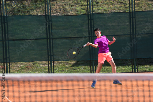 Young tennis player hitting the ball