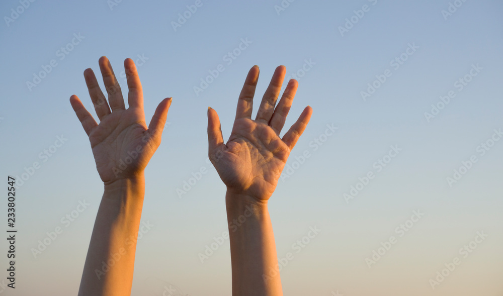 Woman's hand isolated on blue background in summer sky nature. Stop, help, tenth concept with hand up. Gesture symbol number ten in sign language. Say hello / hi or goodbye concept with copy space.