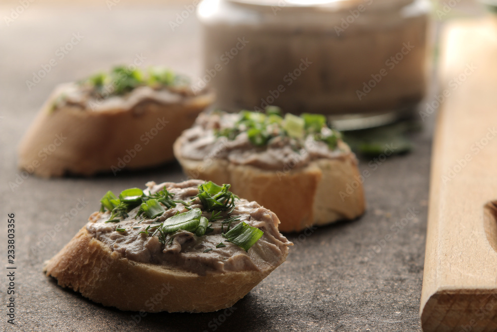 Fresh homemade chicken liver pate with greens on bread on a dark background. A sandwich. close-up