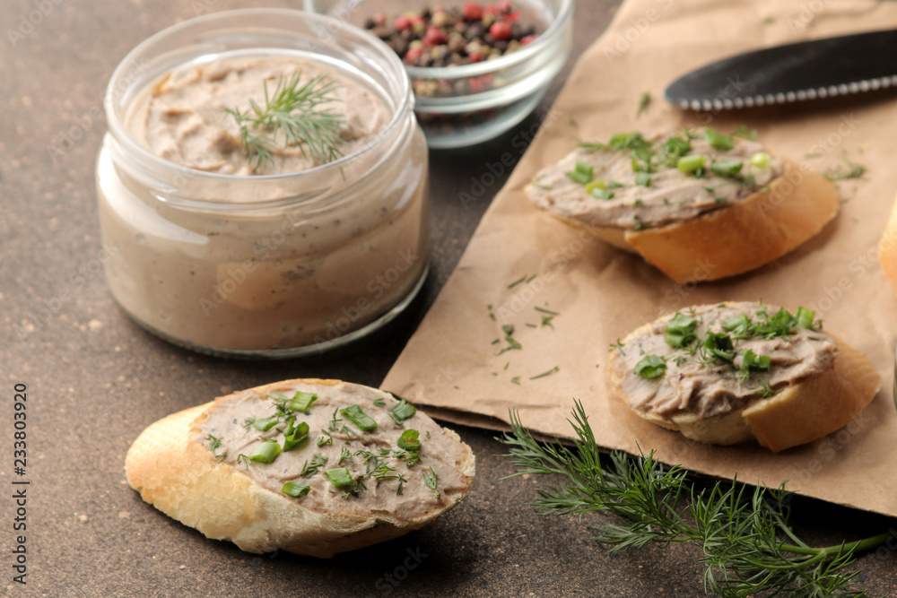 Fresh homemade chicken liver pate with greens on bread on a dark background. A sandwich. Fresh homemade chicken liver pate with greens on bread on a dark background. A sandwich.