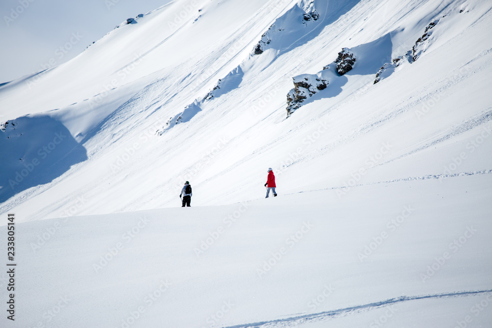 Photo from afar of two sporty skiers in snowy resort