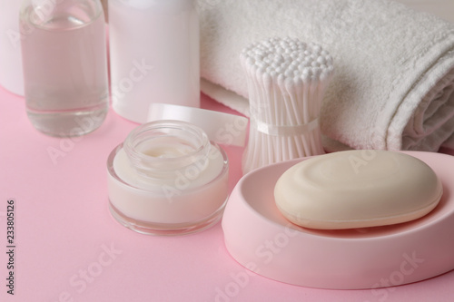 Body and skin care products in white packaging on a pink delicate background. Personal hygiene products.