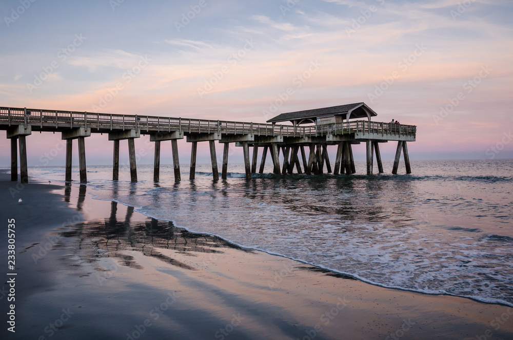Wide angle view of the Tybee Island Pier in Georgia. Colorful sunset with pinks and purple colors in the sky