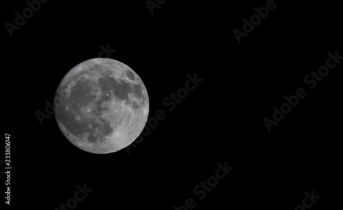 Full moon on dark sky background. Free copy text space.
