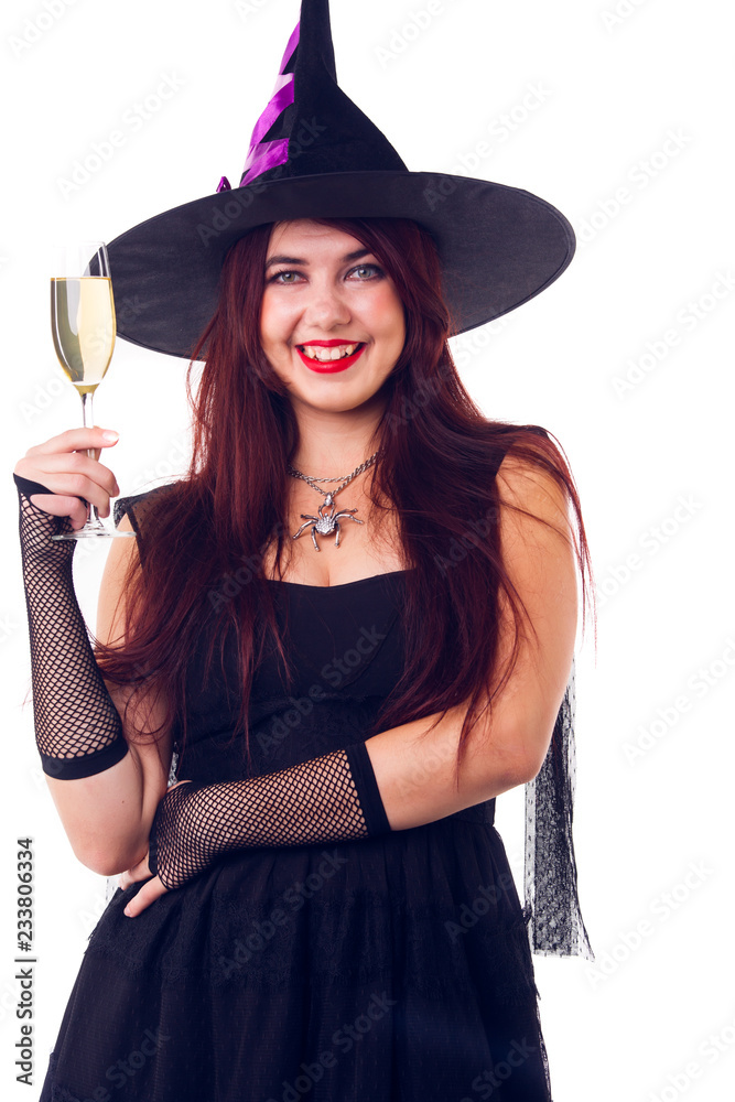 Picture of happy witch with wine glass with wine in black dress and hat Picture of happy witch with wine glass with wine in black dress and hat