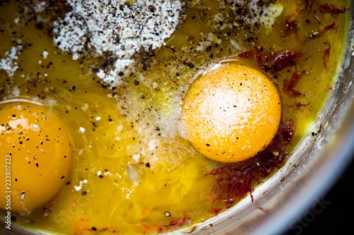 Close up of egg yolks with spices in pan photo