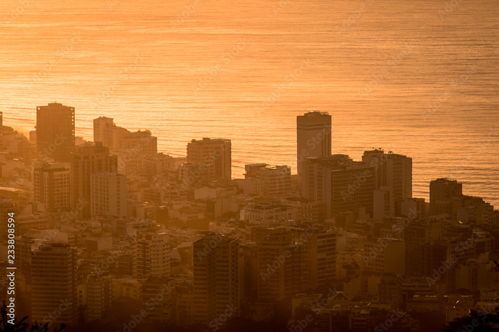 Silhouettes of City Buildings by Sunrise Against the Ocean