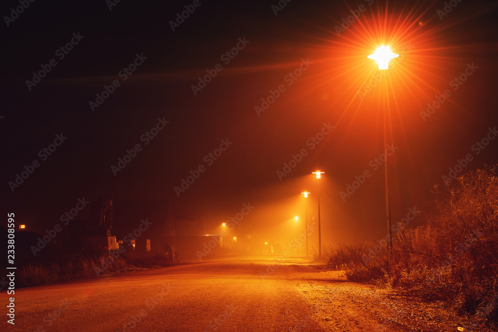 Night street view with nobody out there at evening mist with orange glow from the street lights. Braunschweig, Germany