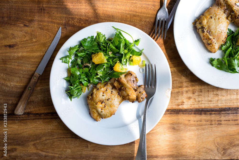 Close up of bay leaf chicken with orange parsley salad served on table Close up of bay leaf chicken with orange parsley salad served on table