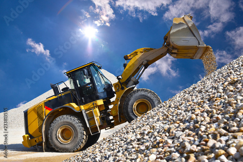 Wheel loader in a gravel pit during mining - heavy construction machine in open cast mining photo