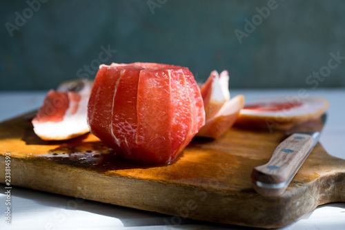 Close up of peeled grapefruit on wooden cutting board photo