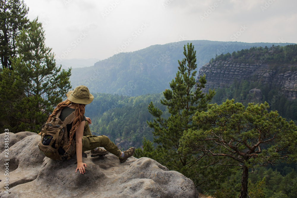 Young woman hiker travel alone in the forest and mountains with backpack	