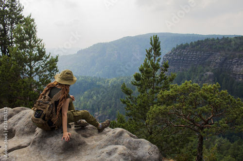 Young woman hiker travel alone in the forest and mountains with backpack 