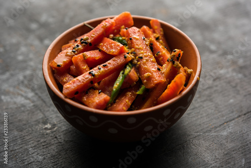 Carrot Pickle / Gajar ka Achar or Loncha in hindi. Served in a bowl over moody background. Selective focus