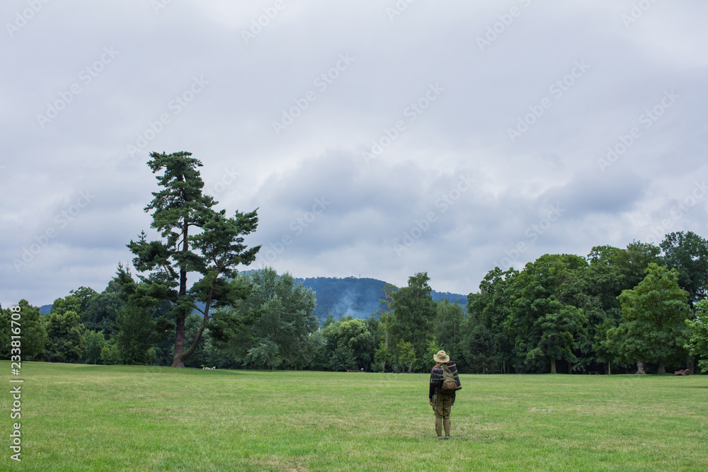 Young woman hiking on the spring meadow, mountains and forest on background Young woman hiking on the spring meadow, mountains and forest on background