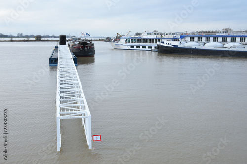 een ondergelopen loopbrug naar een aanlegsteiger door hoogwater in de rivier de Rijn photo