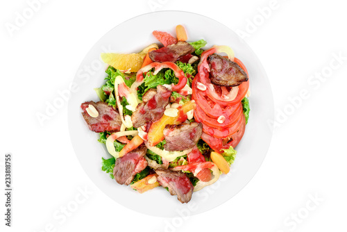 Salad with meat, pear, tomato, on a white plate isolated on white background