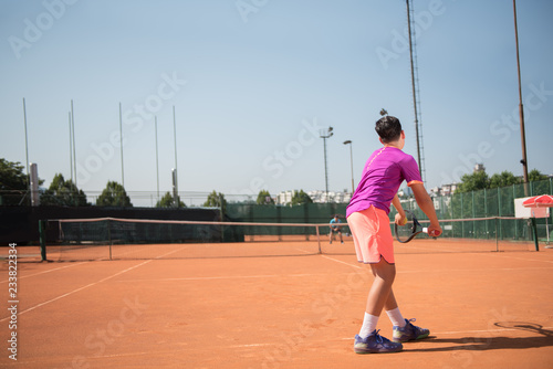 Young tennis player prepares for serving the ball