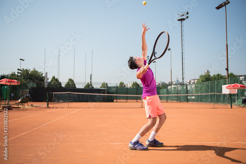 Young tennis player serving the ball