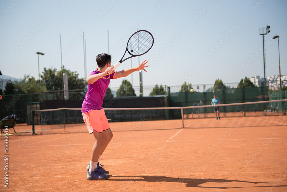 Young tennis player playing forehand